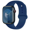 A dark blue silicone sport band for an Apple Watch shown next to the watch.