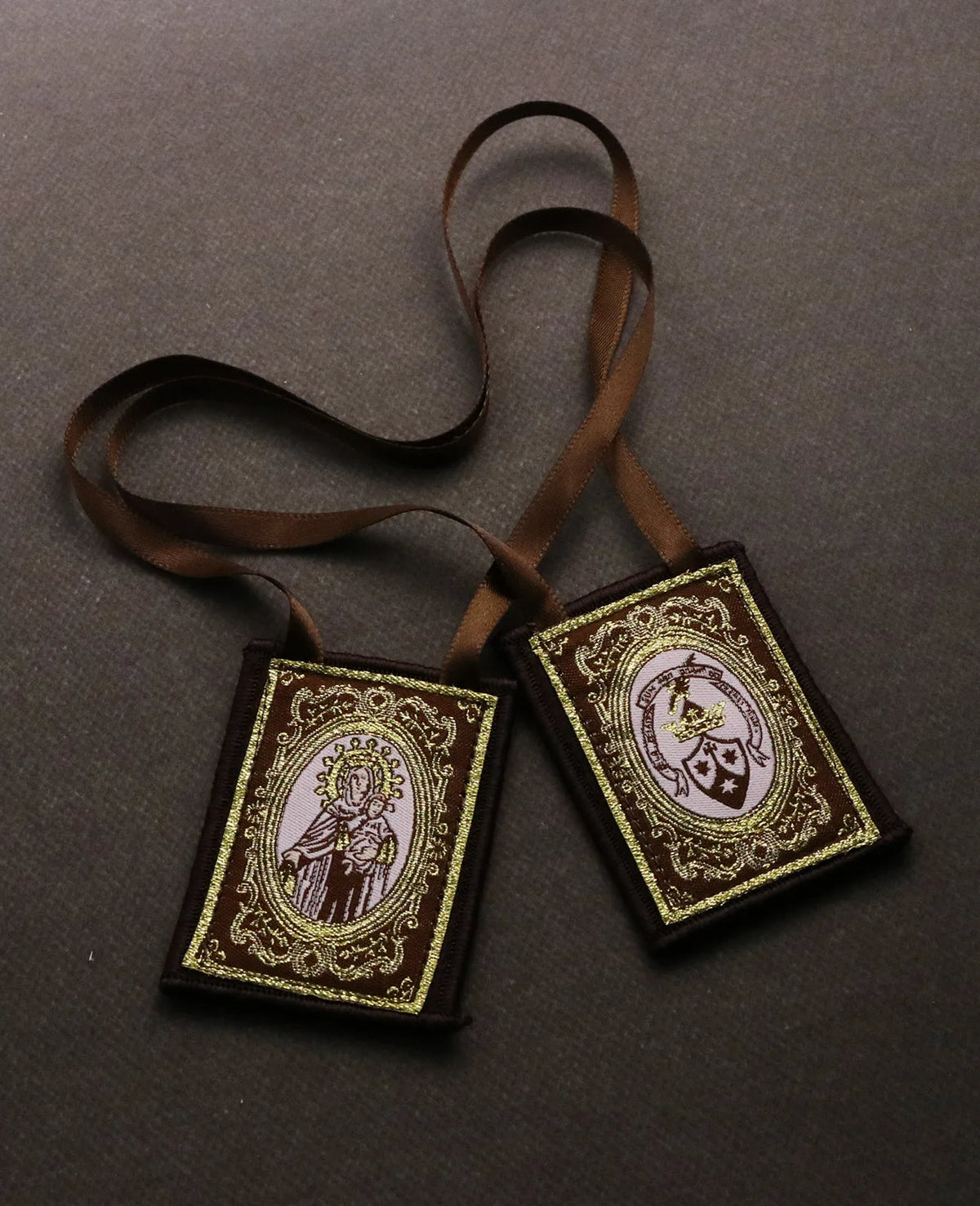 A brown leather cord necklace with an embroidered pendant featuring the Immaculate Heart of Mary.