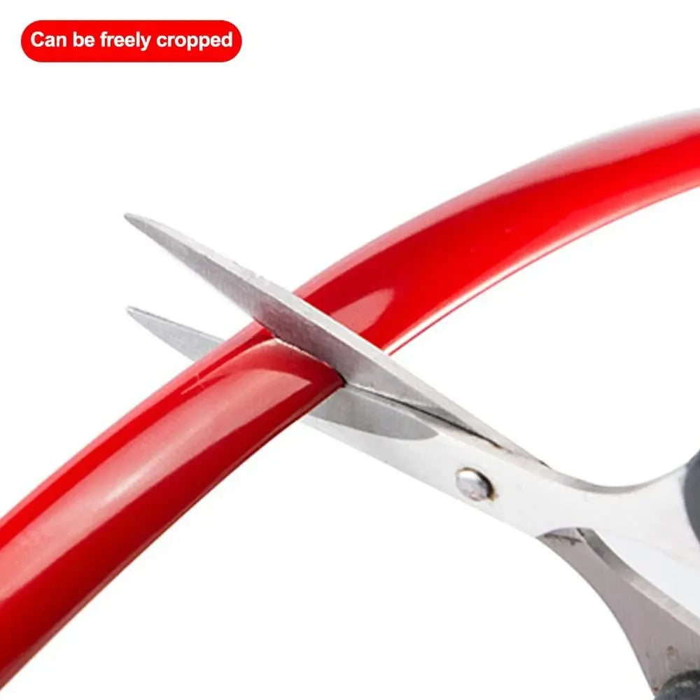 A pair of silver pliers is shown gripping and cutting a flexible red PVC car bumper protection strip.