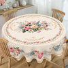Vintage floral tablecloth with pink and blue roses and greenery set on a wooden dining table.