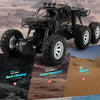 A black six-wheel drive off-road RC car with an alloy body is shown in a desert environment.