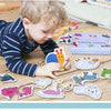 A child is interacting with a wooden animal and vehicle puzzle set featuring various animals and shapes, alongside a storage 