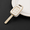 A white TPU key fob cover with a gold accent is shown resting on a white plate.