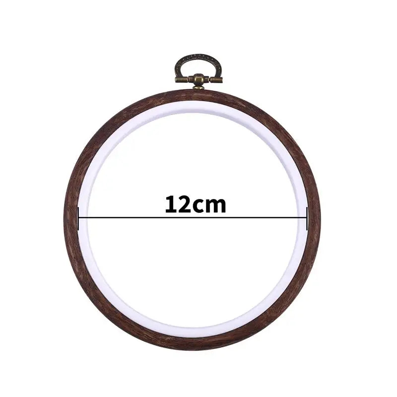 A circular wooden embroidery hoop with a metal loop for cross-stitch and needlework.