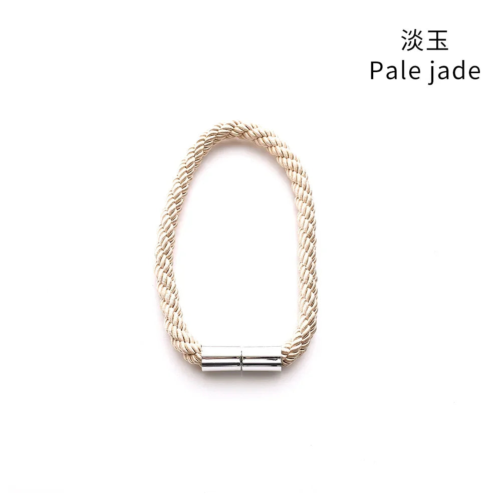 A close-up of a pale jade rope bracelet with a silver magnetic clasp.