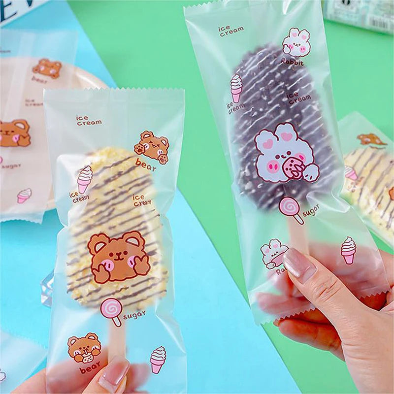 Eine Hand hält einen durchsichtigen Plastikbeutel mit Eiscreme und Süßigkeiten, darunter Hasen- und Bären-Eiscreme, auf einem