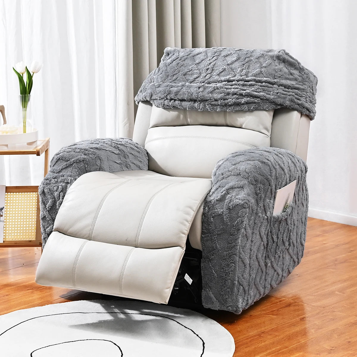 Un ensemble de housses de canapé jacquard décoratif gris, exposé sur un parquet en bois avec des rideaux blancs et une petite