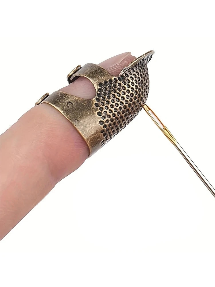 A vintage metal sewing thimble with a finger protector ring is shown on a hand.