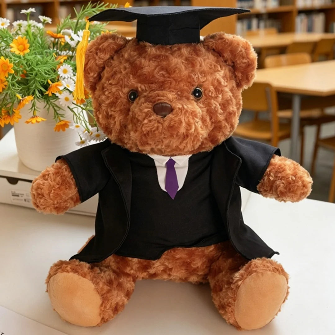 Un ours en peluche brun et duveteux vêtu d'une robe de graduation et d'un mortier.