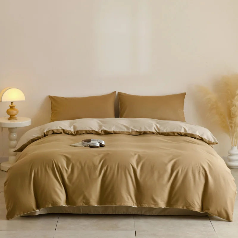 A beige quilted duvet cover set with matching pillowcases displayed on a bed against a light wall.