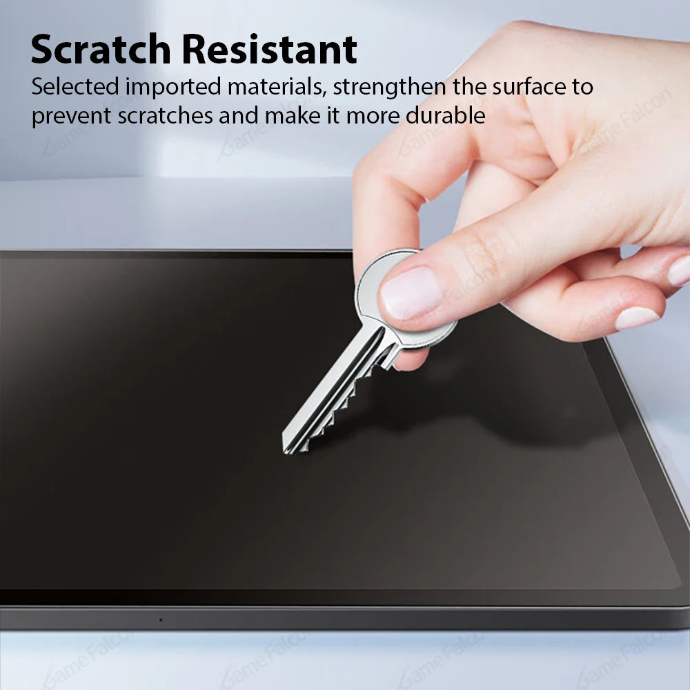 A hand is placing a silver key onto a dark tablet surface, demonstrating scratch resistance.