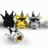 A set of four metal crown valve caps in black, gold, silver, and silver are displayed on a white background.