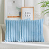 Light blue plush faux fur cushion cover with vertical stripes displayed on a sofa.