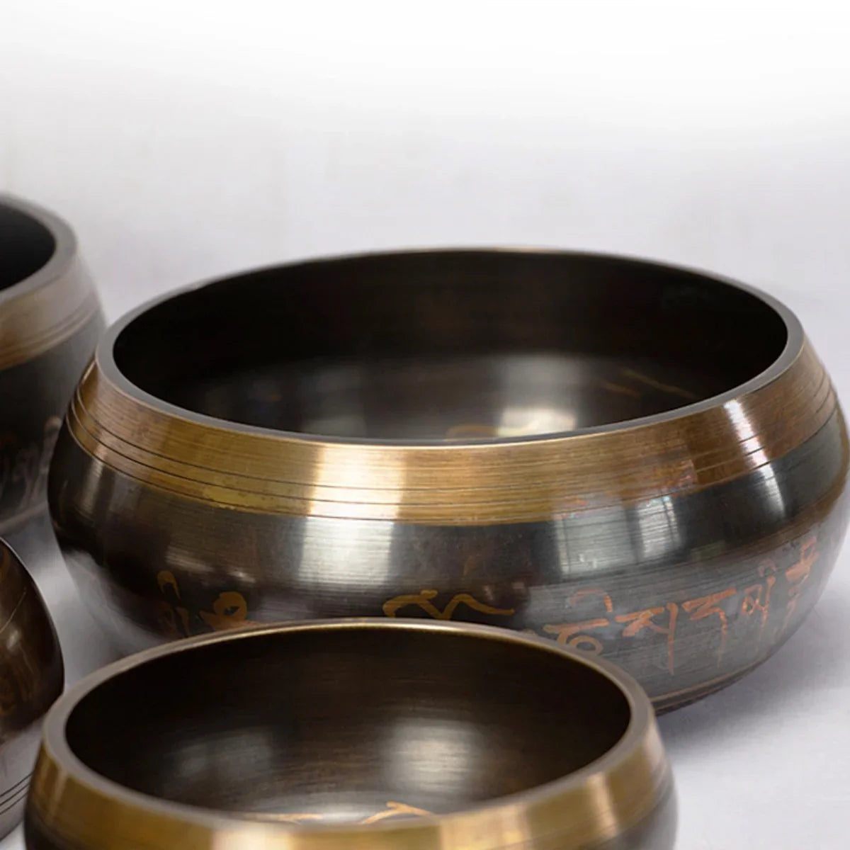 A close-up view of a handcrafted Tibetan singing bowl with a cushion and striker, showing its metallic surface.