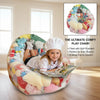 A child sits inside a colorful inflatable plush chair filled with soft plushies and a book in a bright room.