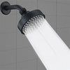 A matte black shower head is mounted on a wall, emitting a strong stream of water.