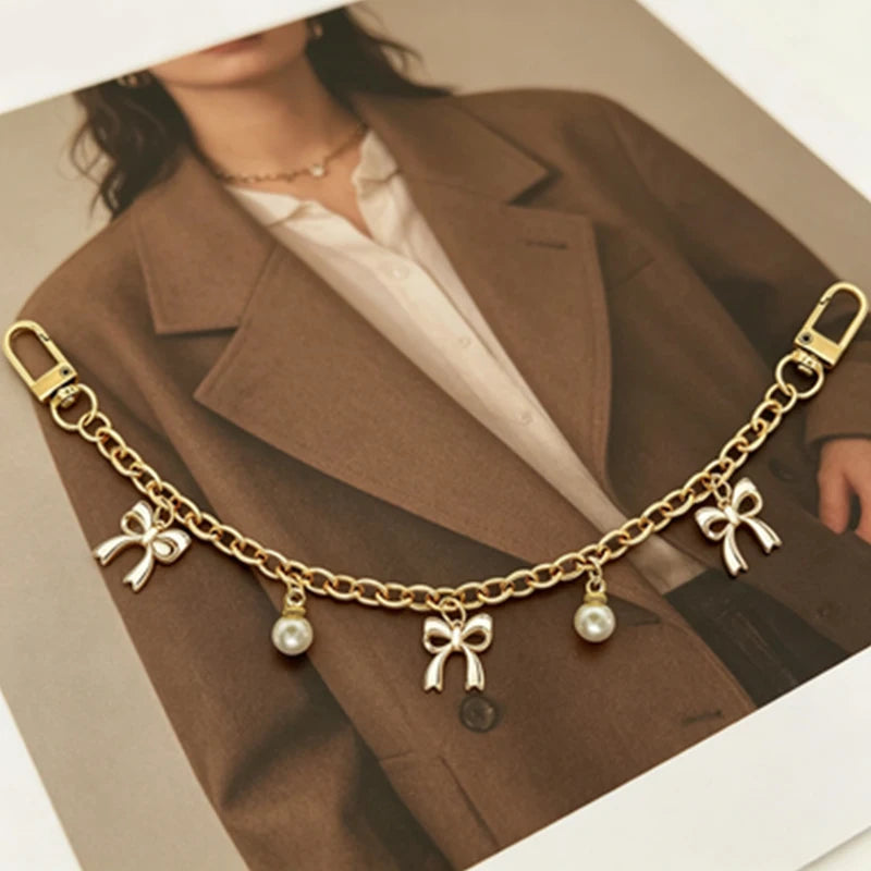 Gold alloy chain with pearl and bow decorations used as a bag handle