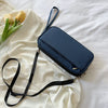 A navy blue waterproof family passport and document organizer wallet with a black strap lying on a white fabric.