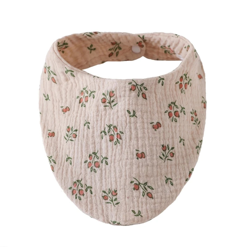 A light pink organic cotton muslin baby bib with a textured pattern and absorbent band.