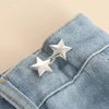 Silver star brooch belt buckle clipped onto a denim fabric