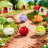 A collection of hand-painted resin vegetable figurines, including a mushroom, eggplant, tomato, and squash, arranged on a dir