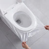 A hand is placing a plastic waterproof toilet seat cover over a white toilet bowl.