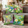 A collection of five floral throw pillows featuring various wildflowers in shades of green, pink, yellow, and purple on a gra