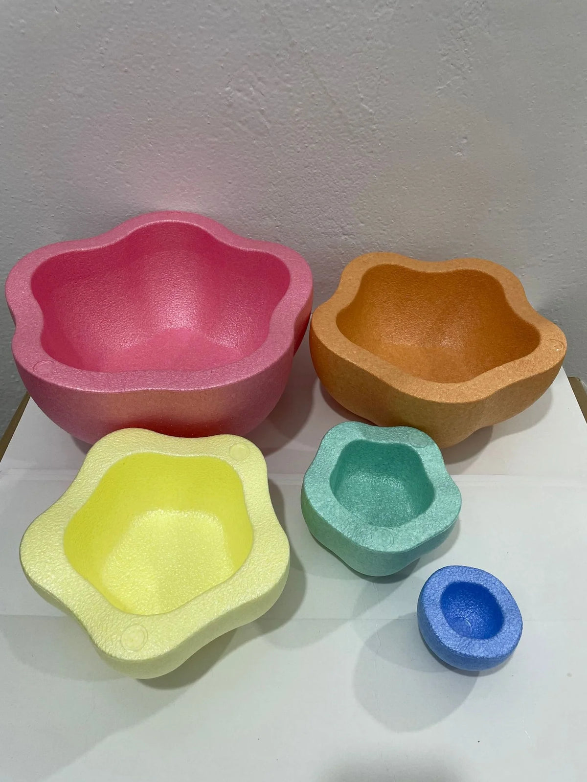 Five brightly colored plastic stepping stones in pink, orange, yellow, green, and blue for sensory and motor skill developmen