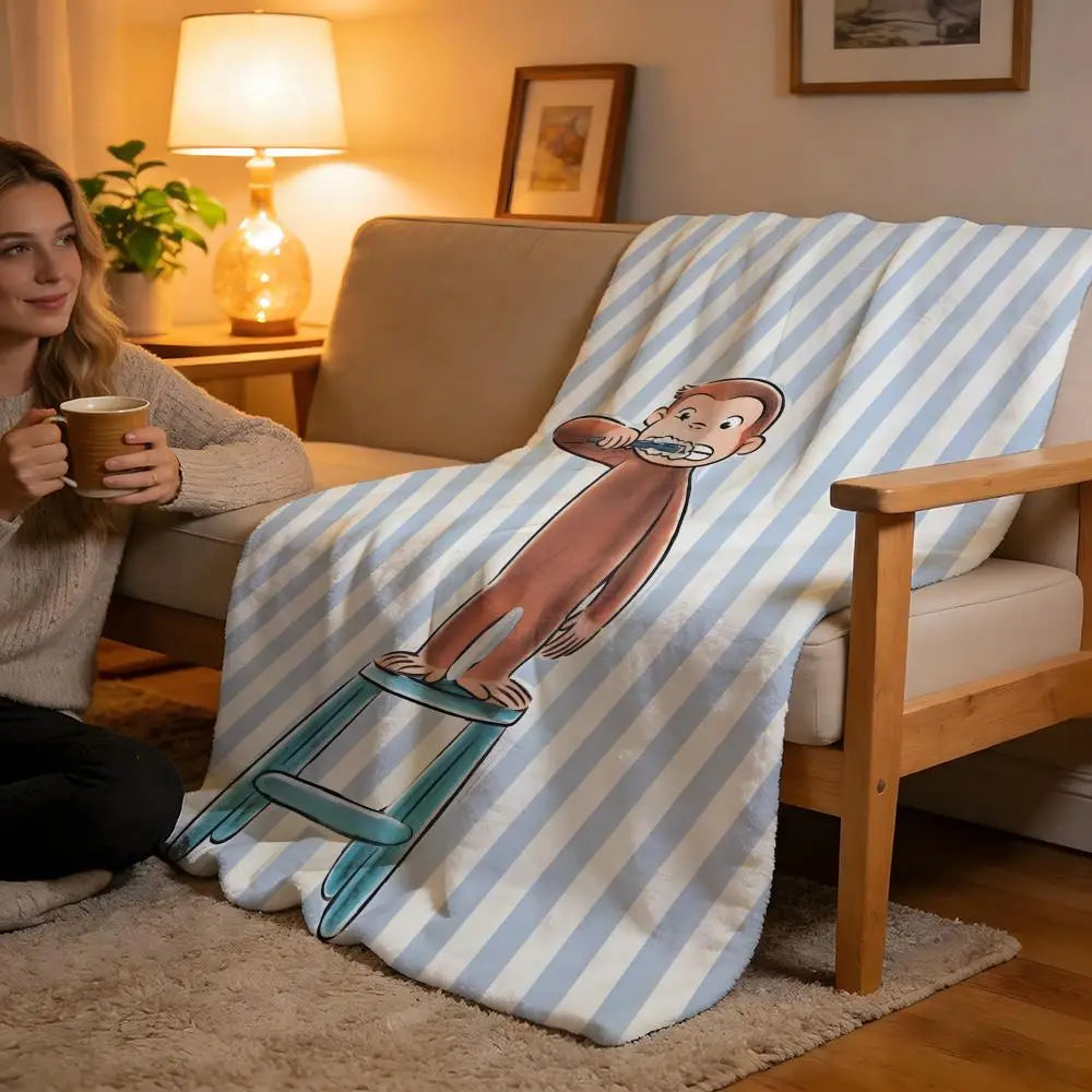 A person is sitting on a sofa with a striped blanket featuring a cartoon character.