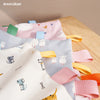 A close-up of a baby sensory tag comfort blanket with soothing teether in pink, blue, and yellow colors.