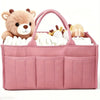 A pink floral diaper organizer bag featuring a teddy bear charm and multiple compartments for baby supplies.