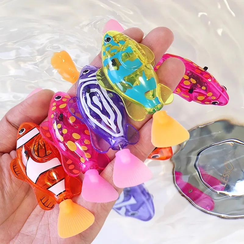 A hand holds several colorful light-up sensor swimming fish toys in water.