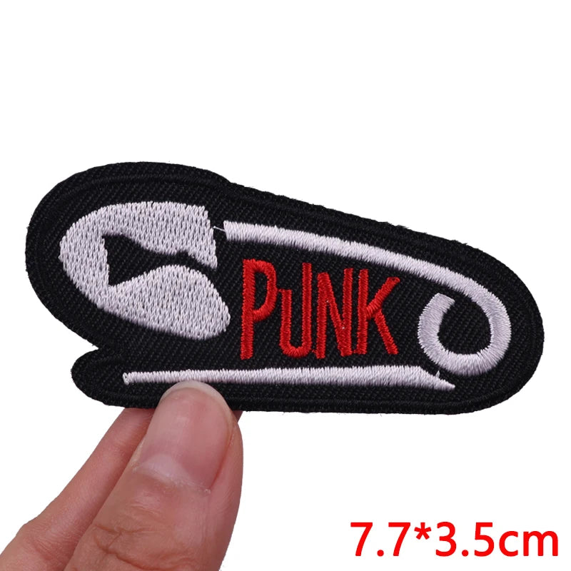 Black embroidered iron-on patch featuring a white stylized punk design
