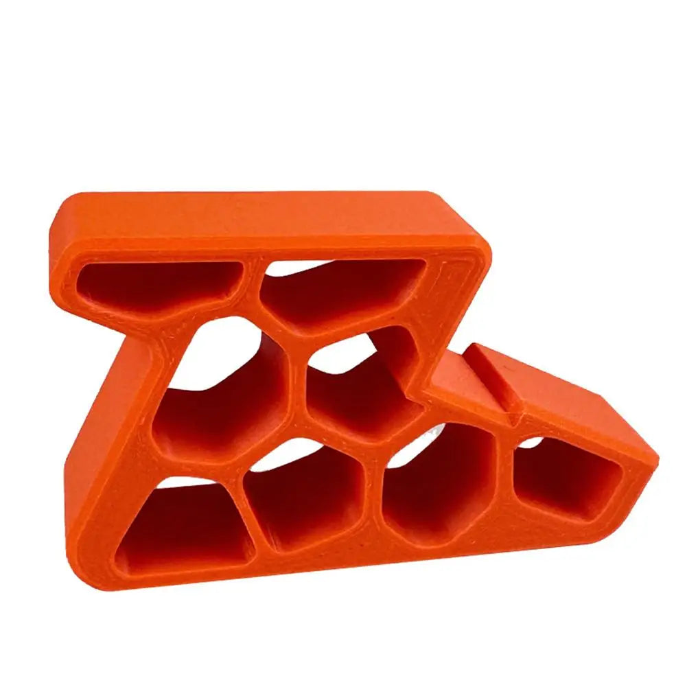 An orange heavy-duty non-slip door stopper wedge with a honeycomb structure.