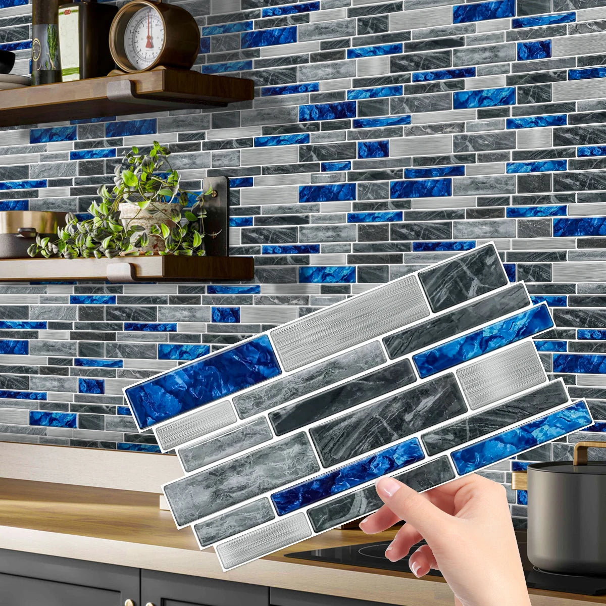 A hand places peel and stick waterproof tile stickers on a gray and blue marble backsplash.