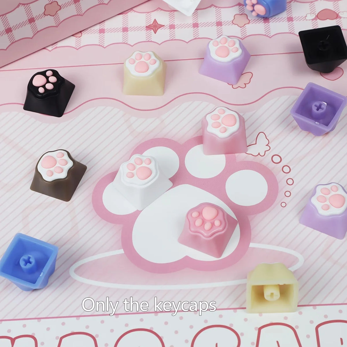 A collection of pink and purple silicone keycaps shaped like cat paws and hearts for MX switches on a pink background.