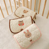 Three quilted beige and pink foldable portable diaper changing pads are displayed on a white surface.