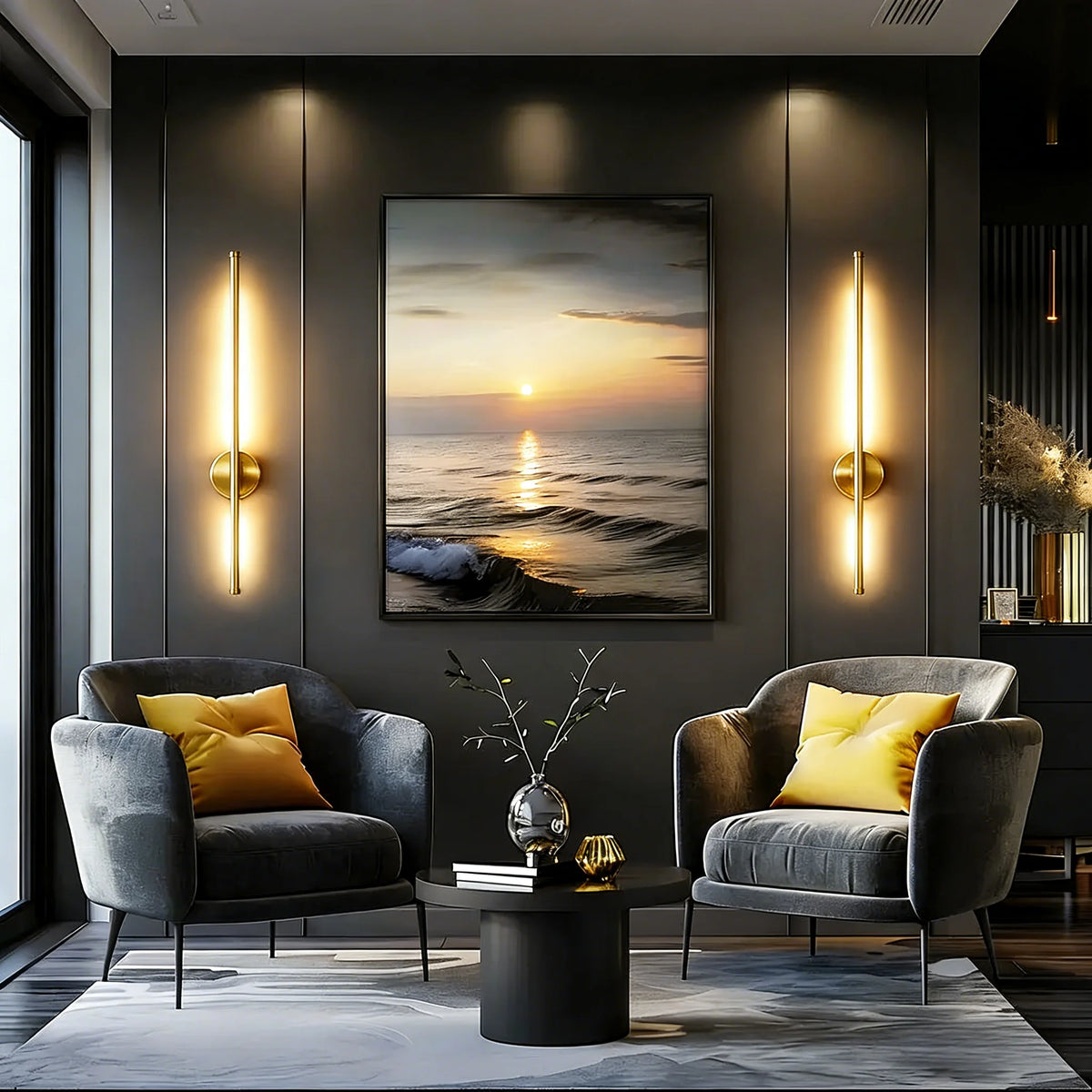 Two modern gold LED wall sconces illuminate a living room with dark gray furniture and a sunset view.