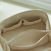 A light beige leather travel makeup organizer bag shown open with a soft lining and drawstring closure.
