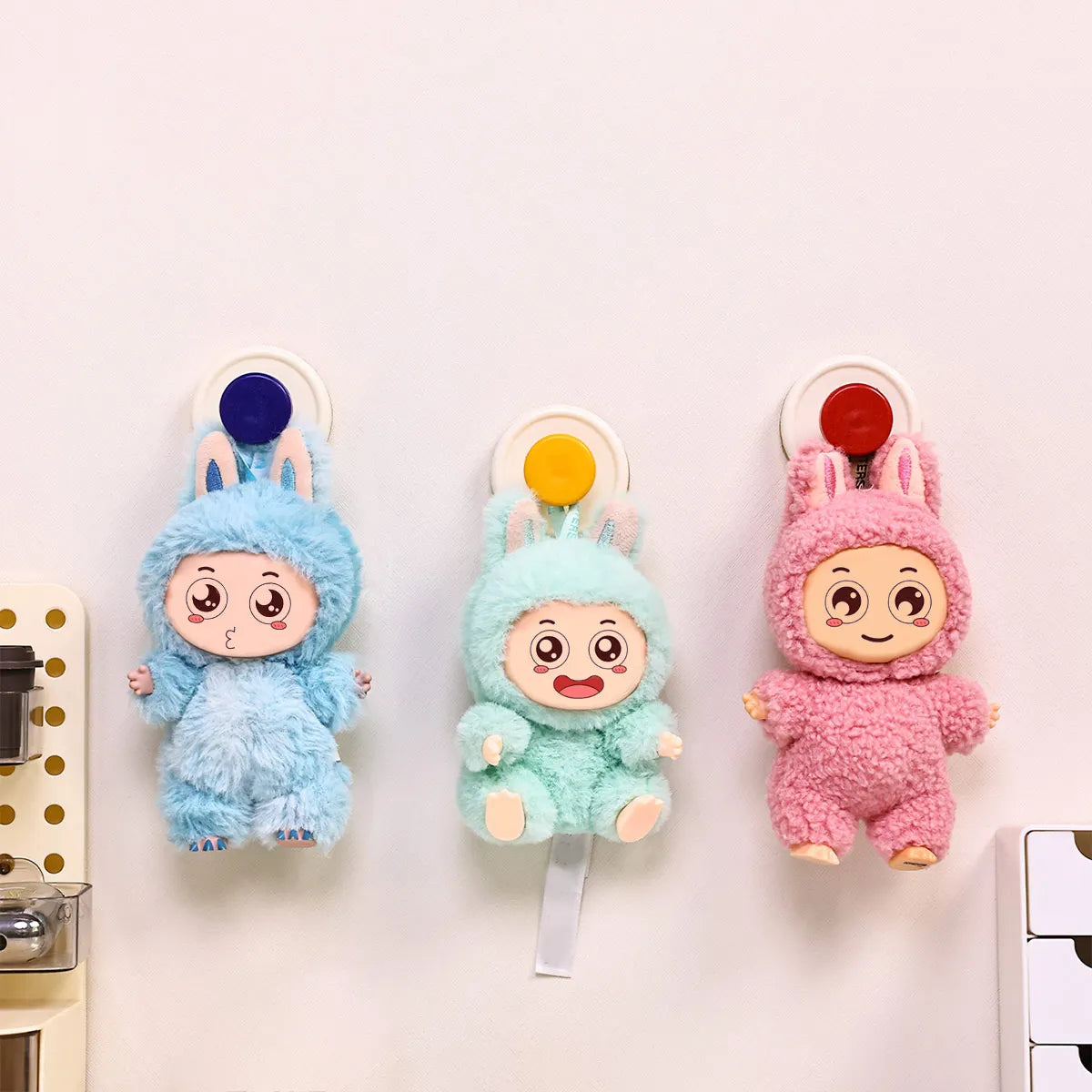 Three plush bunny suction cup hooks in blue, mint green, and pink for hanging items