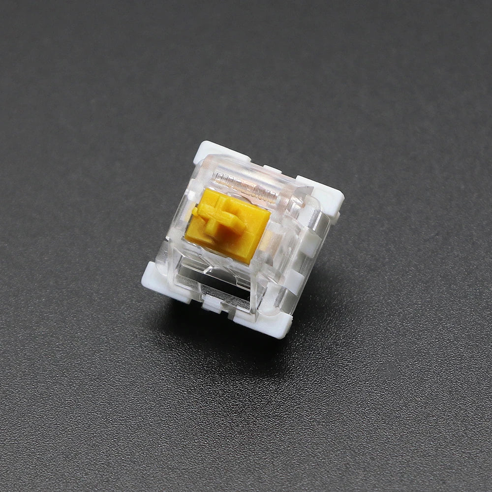 A close-up view of a white plastic 3-pin mechanical keyboard switch with a yellow housing.