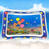A clear inflatable water play mat filled with colorful plastic fish and aquatic life for baby sensory development.
