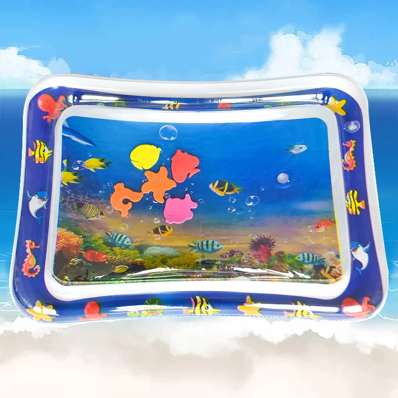 A clear inflatable water play mat filled with colorful plastic fish and aquatic life for baby sensory development.