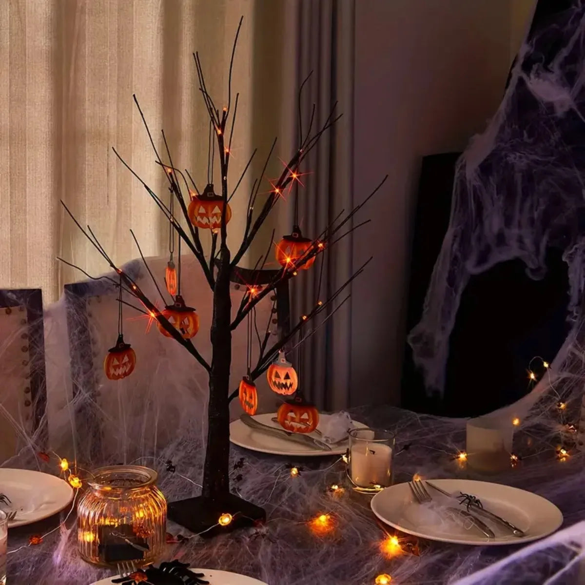 An LED Halloween birch tree decorated with orange and purple lights on a dark surface.