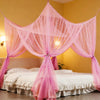 A pink mosquito net bed canopy draped over a white bed in a yellow room.