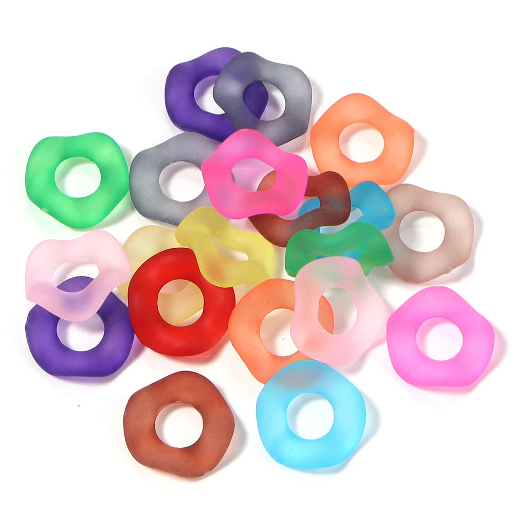 A collection of colorful acrylic spacer beads in various shades including purple, pink, green, and orange.