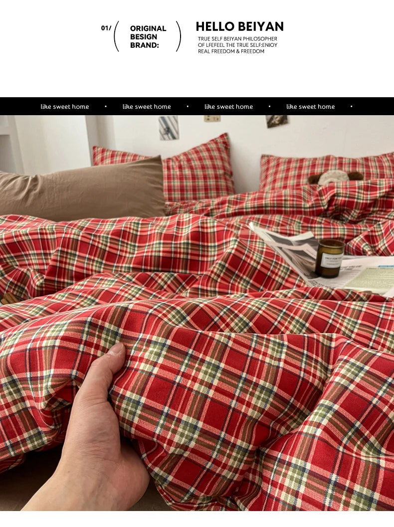 A close-up of a red and green plaid duvet cover set being held by a hand, showing the texture and pattern of the fabric.