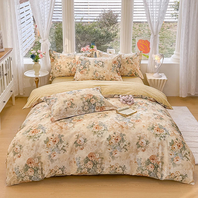 A beige floral printed duvet cover set with matching pillows displayed on a bed near a window.