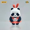 A cute blind box panda figure with white fur, black patches, and an orange-red outfit.