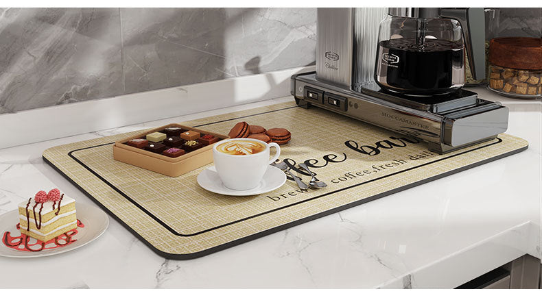 A light wood coffee mat is placed on a marble countertop next to a coffee maker and various coffee accessories.